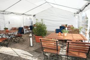 a white tent with tables and chairs and plants at Gasthaus zur Krone in Feilbingert