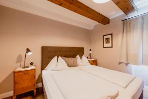 a bedroom with a large white bed and a window at Zur Nandl in St. Wolfgang