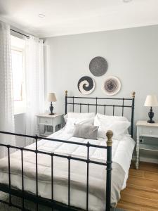 a bedroom with a black bed with white sheets at Quinta Costa da Estrela in Gouveia