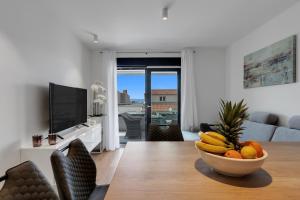 a living room with a bowl of fruit on a table at Apartman Elite in Makarska