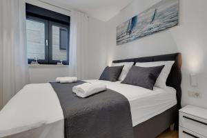 a bedroom with a large white bed with two pillows at Apartman Elite in Makarska