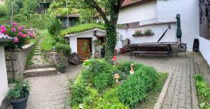 un jardín con un banco y algunas plantas y flores en Casa Santa en Sighişoara