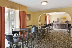 a bar with tables and chairs in a restaurant at Days Inn by Wyndham Charlotte/Woodlawn Near Carowinds in Charlotte