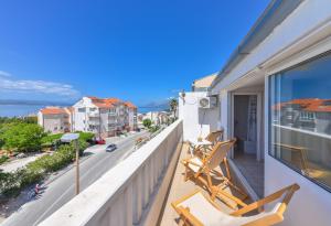 a balcony with chairs and a view of a street at House Santro in Baška Voda