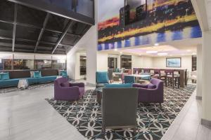 a lobby with couches and chairs and a bar at La Quinta by Wyndham Festus - St. Louis South in Festus
