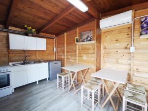 a kitchen with wooden walls and tables and chairs at Villa Torre Dell'Altomare con piscina, blocco n2 - Apulia Home in Alliste