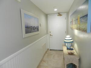 un pasillo con una puerta blanca y una mesa en Vacation in Comfort and luxury - "THE SHERWIN" Oceanfront Condominium 906, en Daytona Beach Shores