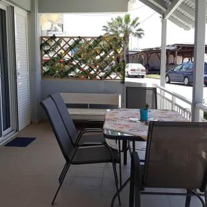 patio con tavolo e sedie sotto il portico di Vasileiadou Coastal Rooms a Flogita