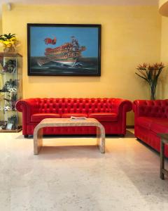 a living room with a red couch and a table at Hotel Alverì in Mestre