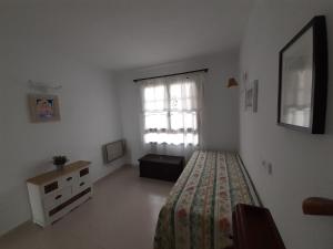 Un dormitorio con una cama y una cómoda y una ventana. en Can Mascarat, en Altea