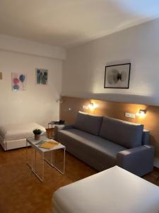 ein Wohnzimmer mit einem Sofa und einem Tisch in der Unterkunft Hotel Patricia in Torreguadiaro