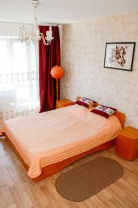 オムスクにあるApartment on 70 let Oktyabryaのベッドルーム1室(ベッド2台、赤いカーテン付)