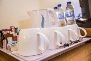 a group of cups sitting on a tray with water bottles at Tollgate Hotel & Leisure in Stoke on Trent