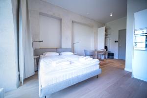 Un dormitorio con una gran cama blanca y una mesa en Baltic Accommodation - Urban Studio Apartment, en Tallin