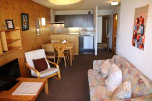 sala de estar y cocina con sofá y mesa en Iris CONFORTABLE & PLEASANT apartments by Alpvision Résidences, en Veysonnaz