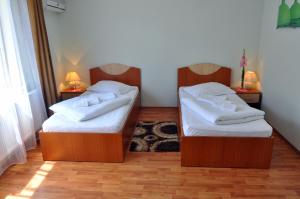 two beds in a room with two nightstands and sidx sidx sidx at Pensiunea Central in Reghin