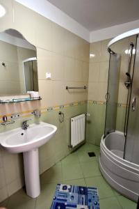 a bathroom with a sink and a shower at Pensiunea Central in Reghin