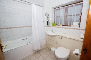 a bathroom with a toilet and a tub and a sink at Tollgate Hotel & Leisure in Stoke on Trent