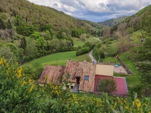 an old house in a valley with a mountain at Gîte Saint Ludan in Rombach-le-Franc