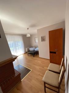 salon z kominkiem, krzesłem i kanapą w obiekcie Apartament U rybaka w mieście Stężyca