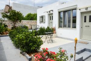 a white house with a courtyard with flowers at Deus Apartments_ Athens Airport in Spata