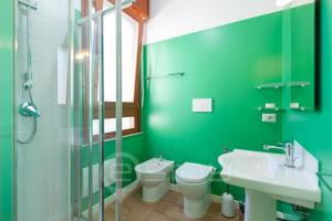 une salle de bain verte avec des toilettes et un lavabo dans l'établissement House Marcella, à Cagliari