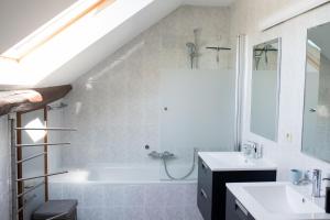 een badkamer met een wit bad en een wastafel bij Les 4 Arbres in Profondeville