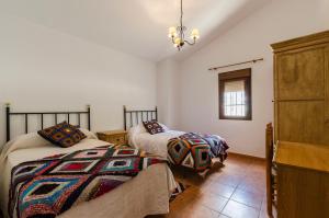 a bedroom with two beds and a dresser at Cortijo Cabrilla in Periana +19 photos