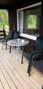 a patio with a table and chairs on a deck at Fossheim Two-Bedroom Cottage in Birkeland