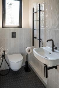 La salle de bains est pourvue d'un lavabo, de toilettes et d'une fenêtre. dans l'établissement MAAJO Boutique Hotel, à Valgalciems