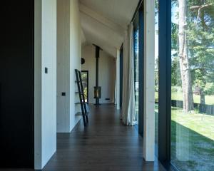a hallway of a house with glass doors and a ladder at MAAJO Boutique Hotel in Valgalciems