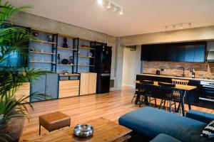 Una sala de estar con un sofá azul y una cocina. en Rooftop Apt with Large Harbor View Terrace, en Constanţa
