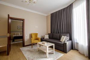 - un salon avec un canapé et une table dans l'établissement Navruz Hotel Tashkent, à Tachkent