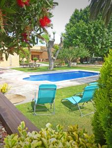 a group of chairs sitting by a swimming pool at Hotel & Golf Ca La Caputxeta in Castelló d'Empúries