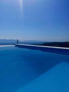 una persona parada en un puente sobre un cuerpo de agua en Georgianna's suite with private pool , 'greysuite', en Kómboi