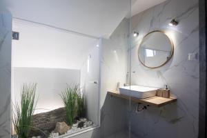 a bathroom with a sink and a mirror at Georgianna's suite with private pool , 'greysuite' in Kómboi