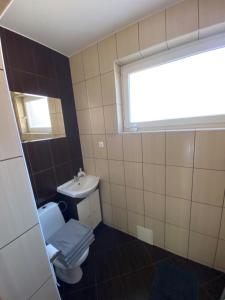 ein Bad mit einem WC, einem Waschbecken und einem Fenster in der Unterkunft Pokoje U rybaka in Stężyca