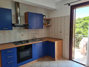 a blue kitchen with a sink and a stove at Blue Lovely House in San Vito lo Capo