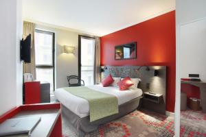 una camera d'albergo con letto e parete rossa di Hotel Eiffel Capitol a Parigi