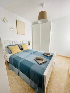 1 dormitorio con 1 cama grande con manta azul en UIM Mediterraneo ATICO Poeta 8 Wifi en Puerto de Sagunto