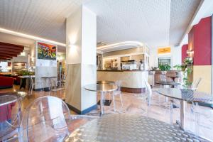 a restaurant with tables and chairs and a kitchen at Hotel Plaza in Turin