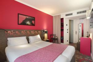 A bed or beds in a room at Hotel Eiffel Capitol