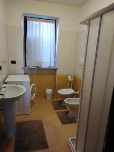 a bathroom with two toilets and a sink and a shower at Appartamenti sapori di campagna in Pescantina