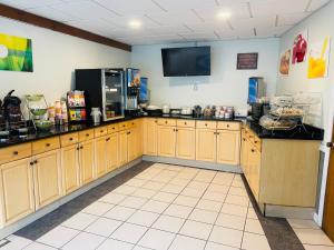 a kitchen with wooden cabinets and a tv on the wall at Quality Inn & Suites in Lincoln
