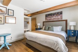 un dormitorio con una cama grande y mesas azules en The Walhampton Arms, en Lymington