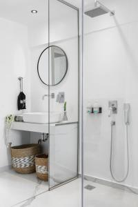 a bathroom with a glass shower with a sink and a mirror at Melo Athens in Athens +73 photos