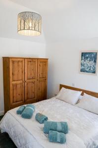 ein Schlafzimmer mit einem Bett mit blauen Handtüchern darauf in der Unterkunft The Annex, Tregoddick Barn in Penzance