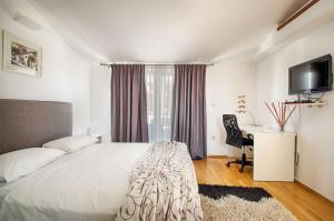 sypialnia z łóżkiem, biurkiem i telewizorem w obiekcie Apartment Heart of Poreč w Poreču