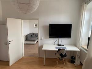 uma sala de estar com uma secretária e uma televisão em Etage1 em Hameln