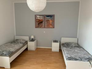 Duas camas num quarto com paredes brancas e pisos em madeira em Etage1 em Hameln